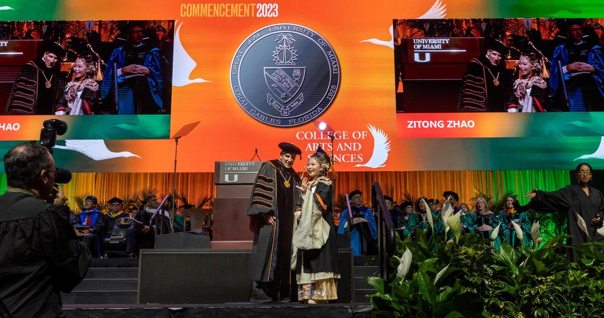 Zitong Zhao, right, meets University of Miami President Julio Frenk on stage for a photo after she received her diploma. Zhao, 22, majored in physics and wants to attend the University of Chicago to get a master’s degree in philosophy next. She dreams of becoming a philosophy professor. She wore a traditional Chinese outfit to honor her identity. “I’m very proud of my culture,” she said. “And today is a special day so they’re fancy.”