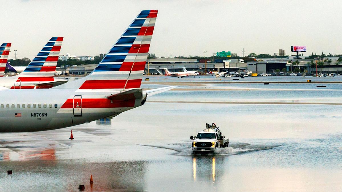 American Airlines airplanes at their terminal as a truck drives through the flooded tarmac at the Fort Lauderdale-Hollywood International Airport on Thursday, April 13, 2023.