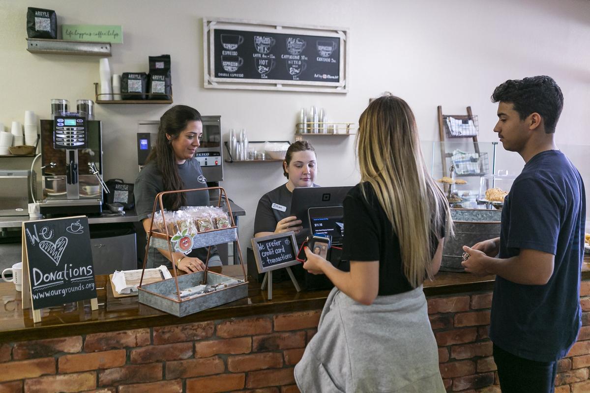Jillian Joerg, 29, center, a cashier, takes an order from customers at Our Grounds in Kendall. Our Grounds is training people with developmental disabilities by offering them work experience as either a barista or a cashier at the coffee shop. Vanessa Vila, left, created this store as an extension of her work an occupational therapist.