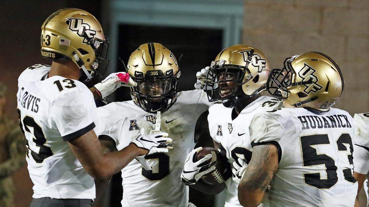Central Florida’s Alex Swenson (30) is congratulated on his touchdown by teammates Dredrick Snelson (5), Bryon Brown (13) and Randy Shannon (53) during the second half of an NCAA college football game against East Carolina in Greenville, N.C., Saturday, Oct. 20, 2018.