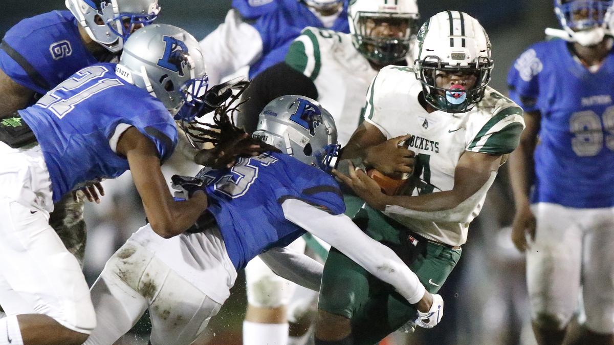 Dillard Panthers defenders attempt to tackle down Miami Central Rockets running back Amari Daniels (4) during the regional 4-6A football championship final game Friday, November 22, 2019 at Dillard HS in Fort Lauderdale