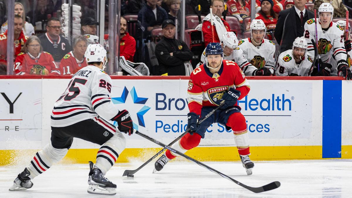 Florida Panthers center Sam Reinhart (13) looks to pass the puck as Chicago Blackhawks defenseman Alec Martinez (25) defends in the first period of their NHL game at Amerant Bank Arena on Saturday, Feb. 1, 2025, in Sunrise, Fla.