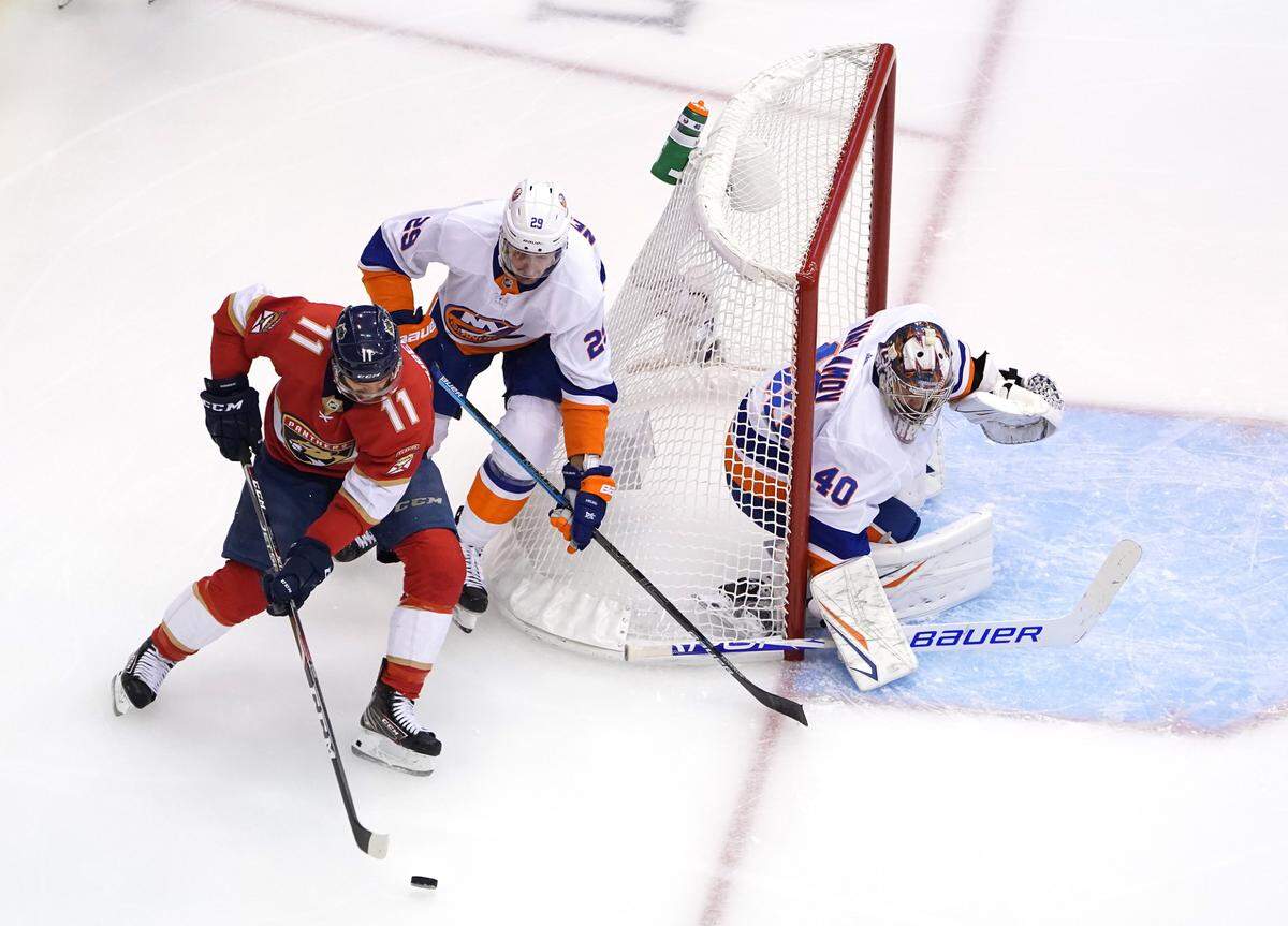 TORONTO, ONTARIO - AUGUST 07:  Semyon Varlamov #40 of the New York Islanders guards his net as Jonathan Huberdeau #11 of the Florida Panthers and Brock Nelson #29 of the New York Islanders wrap around the net in the first period in Game Four of the Eastern Conference Qualification Round prior to the 2020 NHL Stanley Cup Playoffs at Scotiabank Arena on August 07, 2020 in Toronto, Ontario. (Photo by Andre Ringuette/Freestyle Photo/Getty Images)