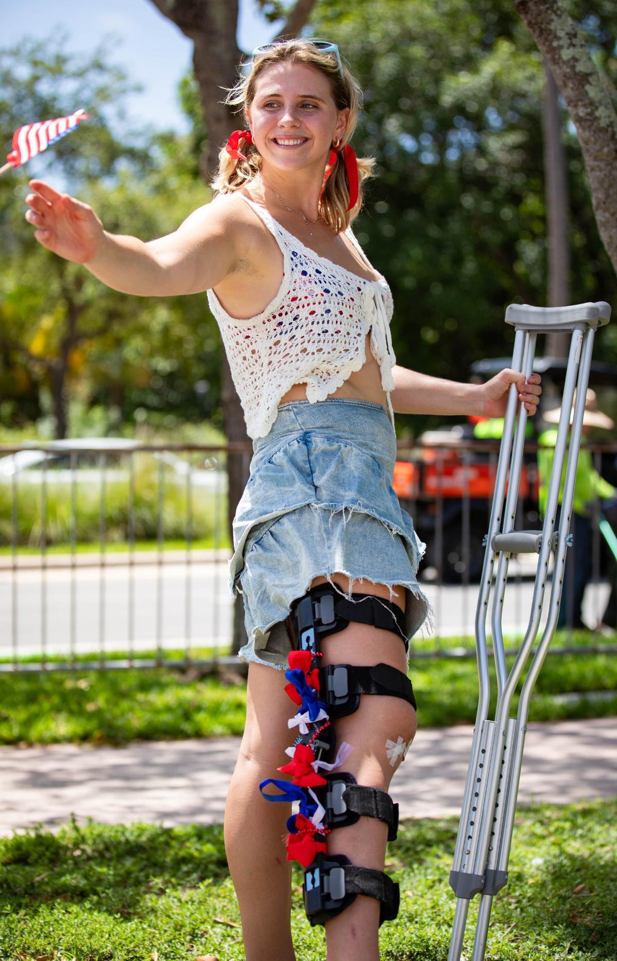 Camille Devaney, 21, receives an American flag at the Key Biscayne July Fourth parade on Thursday, July 4, 2024 on Crandon Blvd & Harbor Dr.