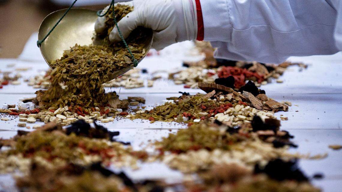 A medical personnel mixing the Chinese herbs at a Traditional Chinese Hospital in Beijing, China, Thursday, July 23, 2009. California researchers are running three clinical trials designed to test whether ancient mushrooms and Chinese herbs used to treat infectious diseases for centuries can help prevent moderately sick COVID-19 patients from progressing to more severe illness.