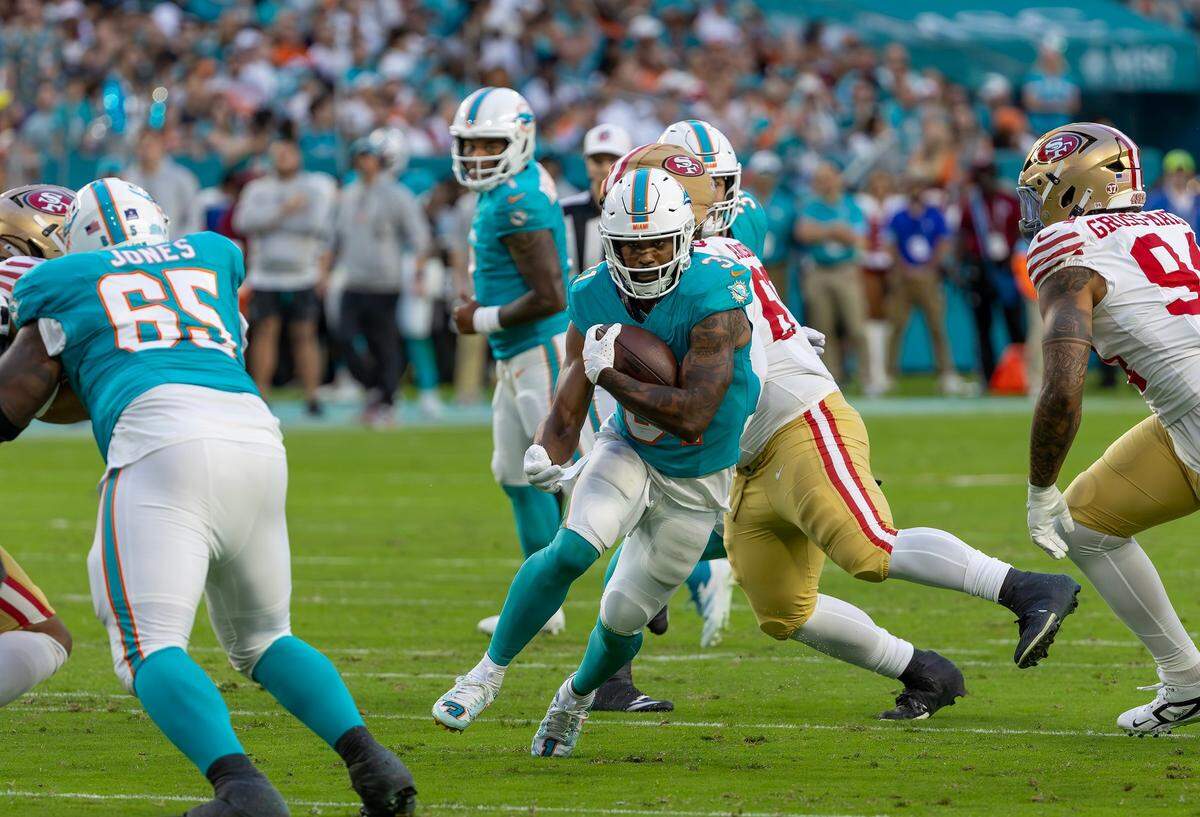 Miami Dolphins running back Raheem Mostert (31) runs with the football during the first half of their NFL game against the San Francisco 49ers at Hard Rock Stadium on Sunday, Dec. 22, 2024, in Miami Gardens, Florida.