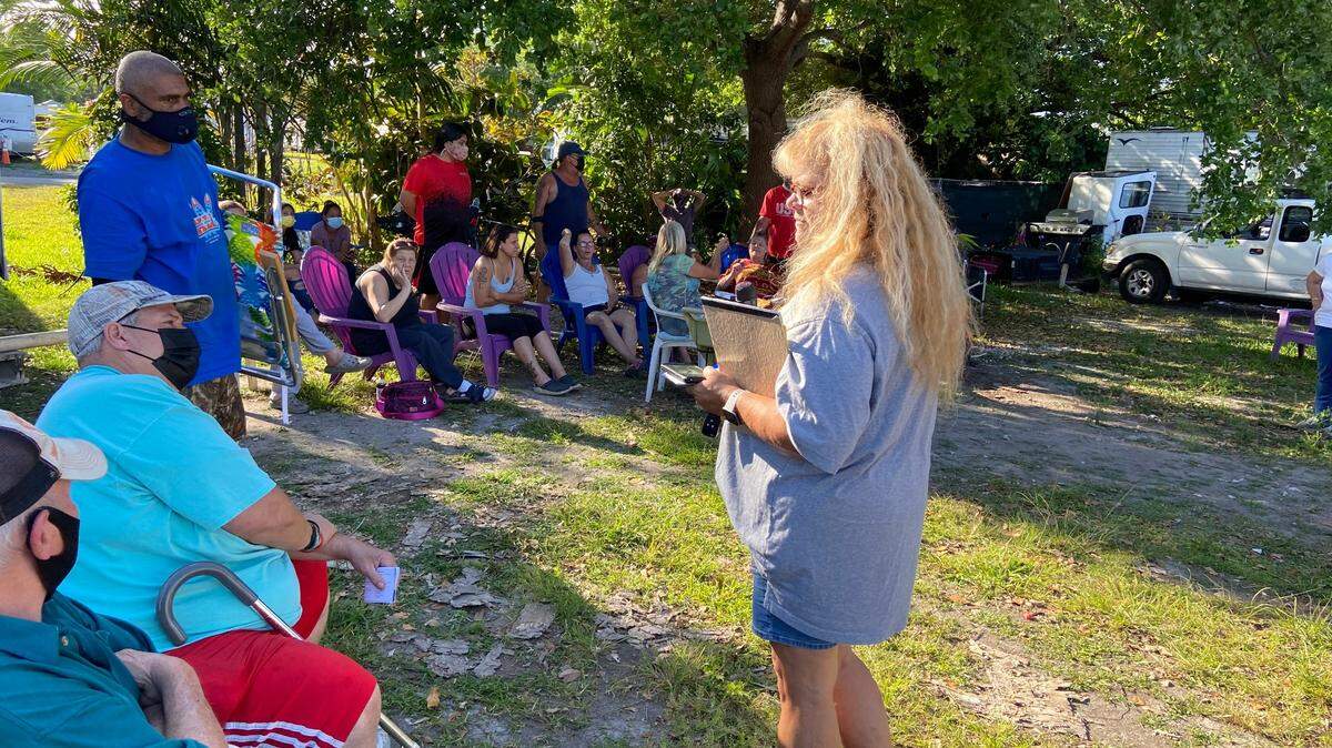 Community activist Carmen Tejada talks with residents of the Florida City Camp Site and RV Park Monday, March 15, about their pending evictions by the government of Florida City, which owns the 15-acre property on Krome Avenue, and is in the process of selling it to developers for $6.8 million.