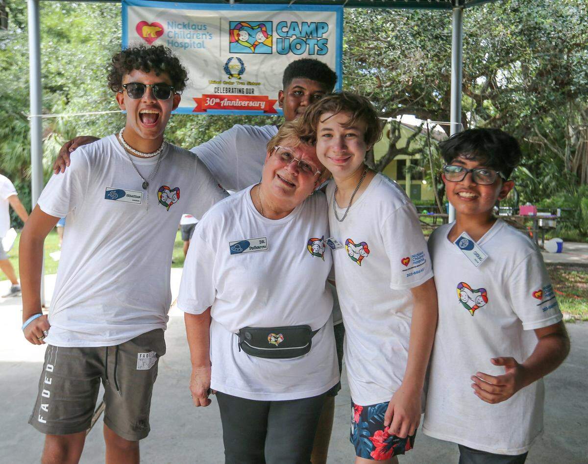 From left, camp participants Sebastian, Ronnie, Chirag, and Shammah in the back, pose with pediatric oncologist Athena Pefkarou on July 23 at Camp U.O.T.S.