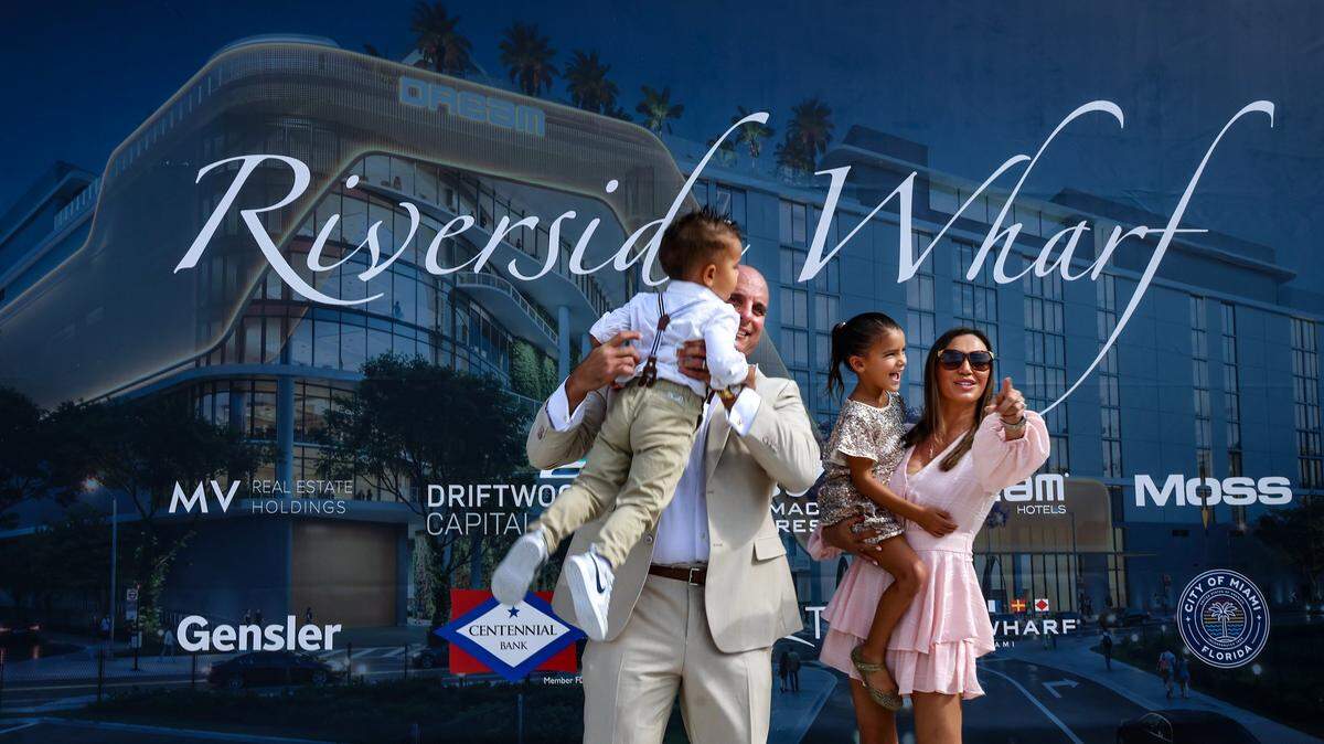Co-founder of Breakwater Hospitality Group Emi Guerra, lifts his son, Amadeus, 2, left, while his daughter, Evarista, 5, is carried by his wife Rikki Guerra, right, as the family attended the Riverside Wharf groundbreaking event. MV Real Estate Holdings (MVREH), Driftwood Capital, and Merrimac Ventures celebrated the official groundbreaking of Riverside Wharf, a transformative $350 million hospitality and entertainment destination rising along the Miami River. Guests gathered at the future site of the project for a milestone ceremony featuring remarks from city officials and representatives of the development team on Thursday, December 4, 2025, in Miami, Florida.