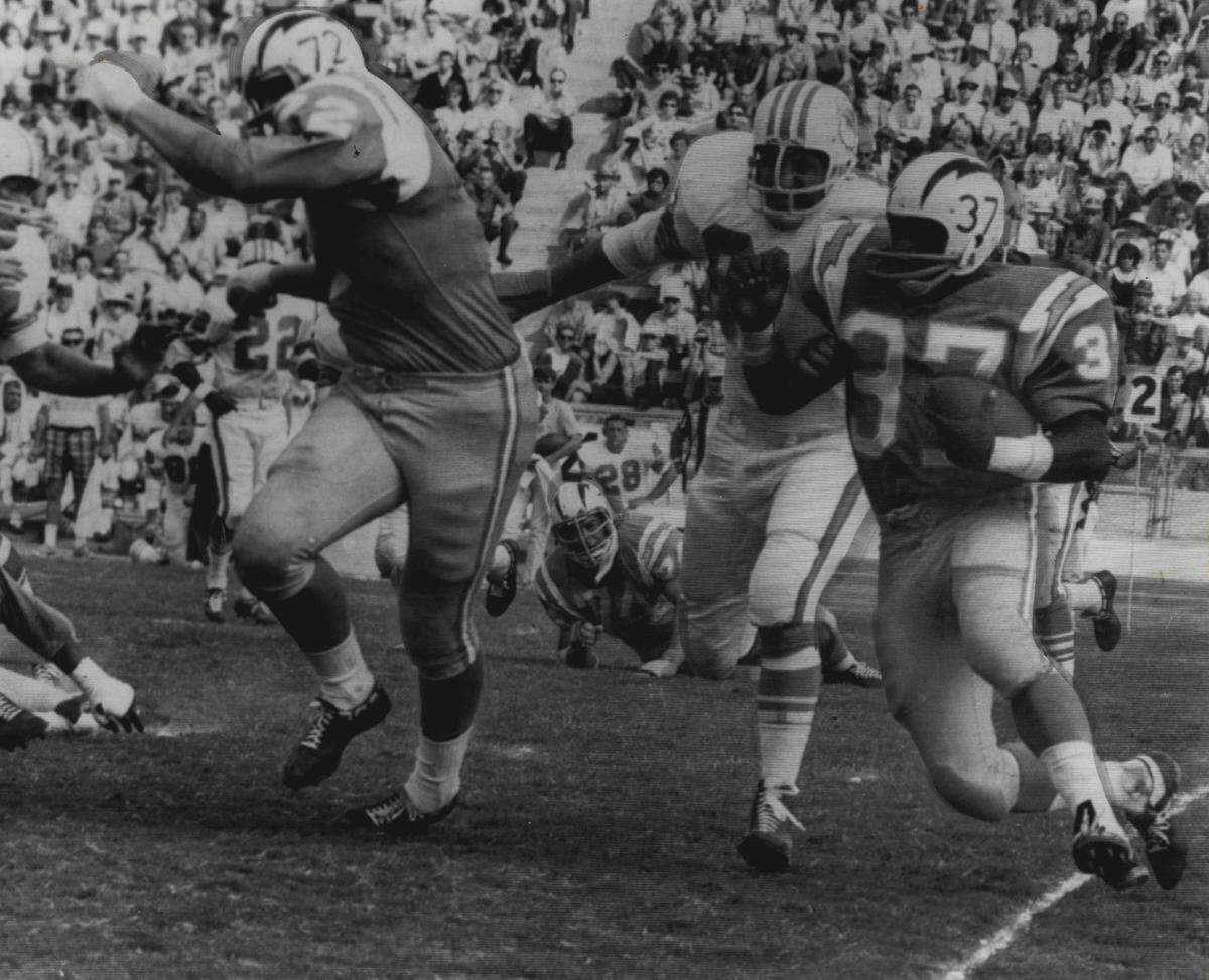 On Oct. 2, 1966, San Diego Charger fullback Gene Foster races for a six-yard gain and a first down in the first quarter the Miami Dolphins during their first season. Miami’s Ed Cooke trails behind Foster.