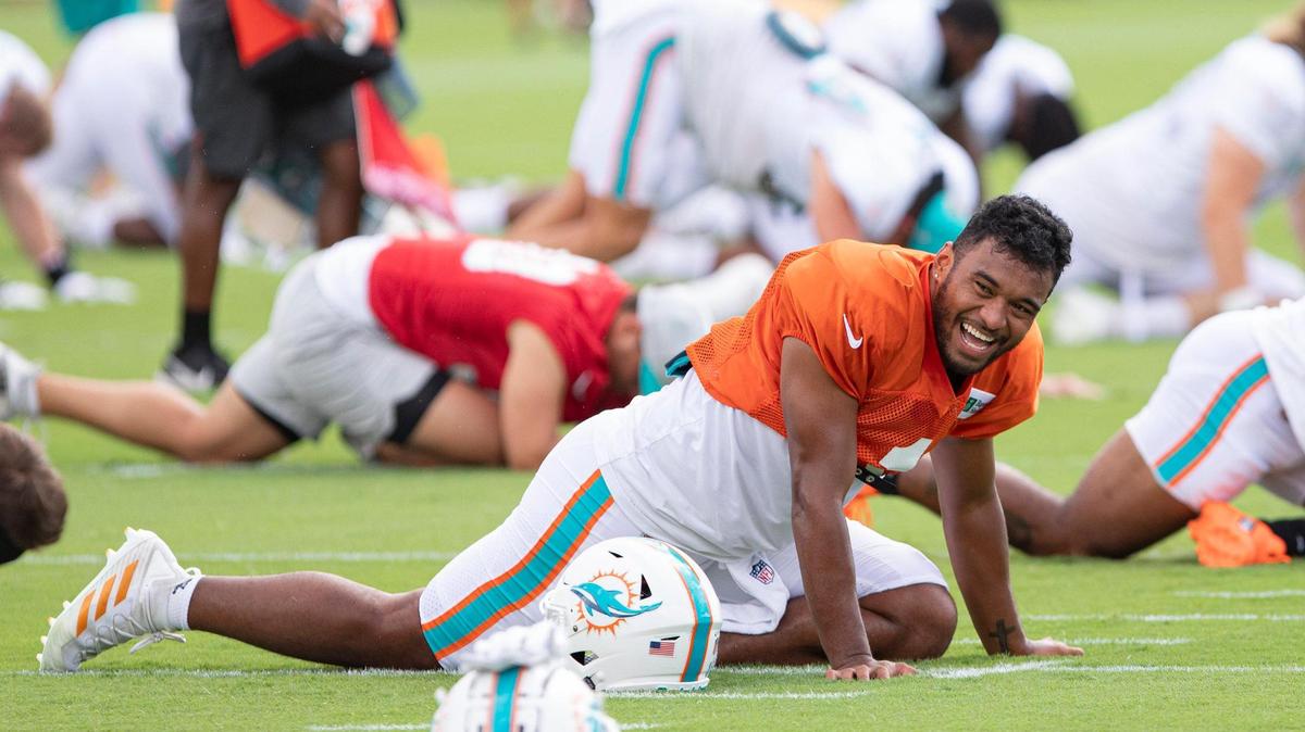 NFL Miami Dolphins quarterback Tua Tagovailoa (1) laughs while stretching during Dolphins Training Camp at Baptist Health Training Complex in Miami Gardens, Florida on Wednesday, August 3, 2022.