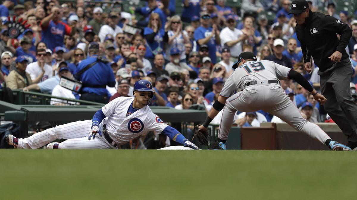 Chicago Cubs’ Javier Baez, left, is safe at third as Miami Marlins shortstop Miguel Rojas applies a late tag during the first inning of a baseball game Thursday, May 9, 2019, in Chicago. (AP Photo/Nam Y. Huh)