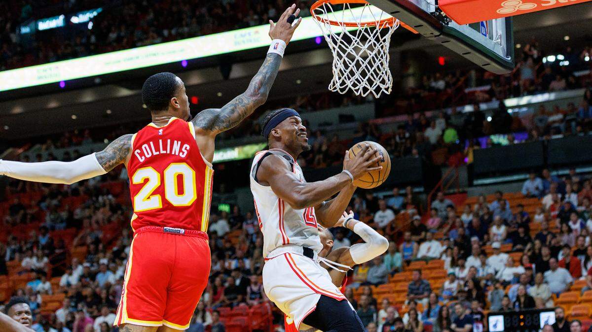 El delantero del Heat, Jimmy Butler (22), va a la canasta contra el delantero de los Hawks, John Collins (20), durante el primer cuarto de un partido de la NBA en el Miami-Dade Arena el sábado 4 de marzo de 2023 en Miami, Florida.