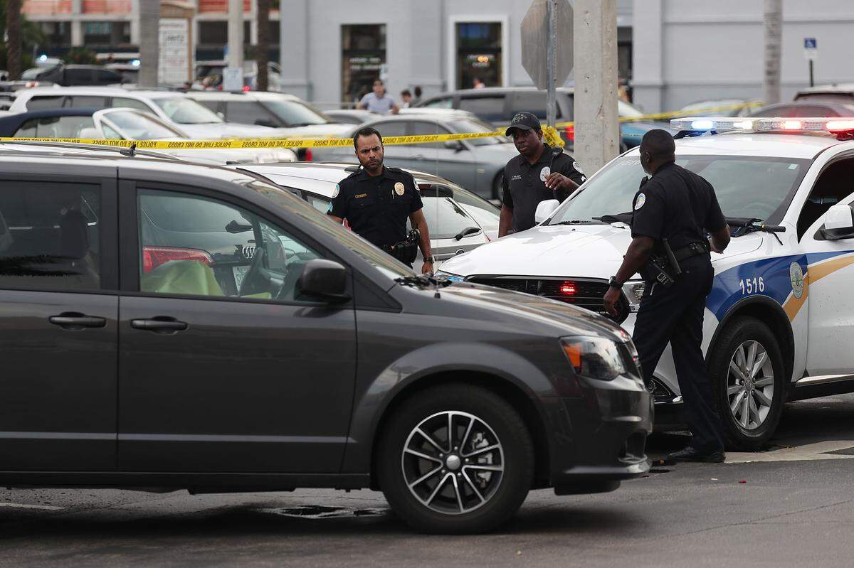 Sunny Isles Beach police officers stand near a van where a man was found shot to death after a nearby shooting that reportedly involved rapper NBA YoungBoy on May 12, 2019.