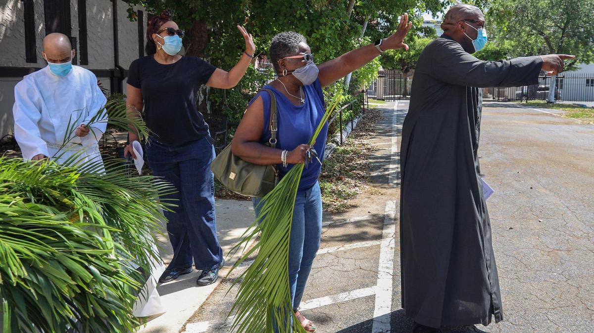 Third from the right, Miami resident Chanel Jackson, Pastor Denrick Rolle, right, volunteers and church staffers wave as parishioners drive-off after receiving their palms. On Sunday, March 28, 2021, Historic St. Agnes Episcopal Church held a drive-thru Palm Sunday event during the start of Holy Week in Miami’s Historic Overtown neighborhood.