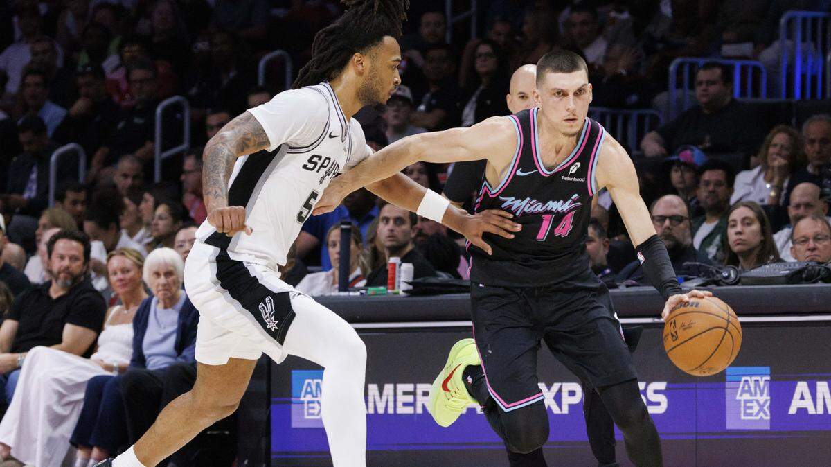 Miami Heat guard Tyler Herro (14) dribbles around San Antonio Spurs guard Stephon Castle (5) during the first half of the game on Monday, March 23, 2026, at the Kaseya Center in downtown Miami, Fla.