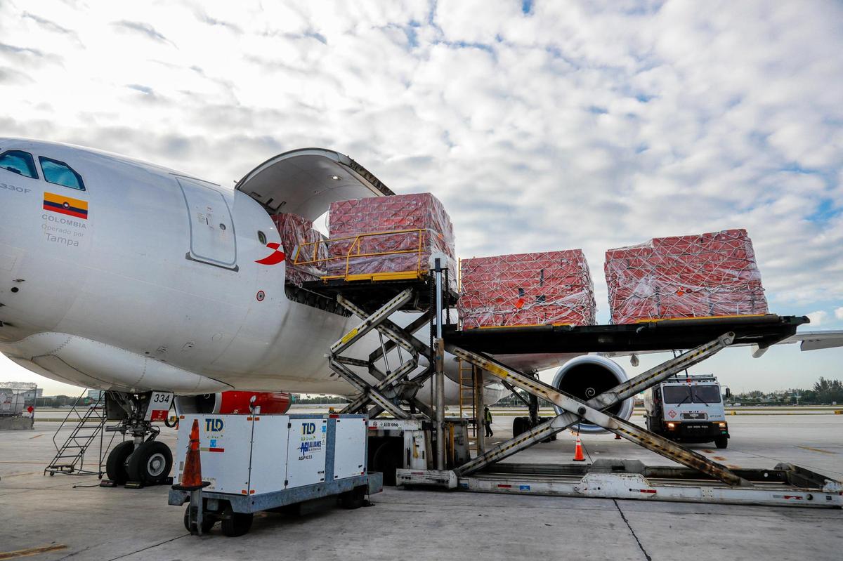 Avianca Cargo employees unload boxes of flowers from a cargo plane at Miami International Airport on Monday, Feb. 6, 2023.