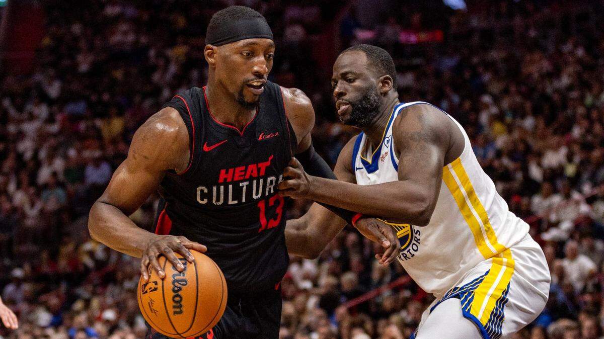 Miami Heat center Bam Adebayo (13) drives on Golden State Warriors forward Draymond Green (23) during the second half of an NBA game at Kaseya Center in Miami, Florida, on Tuesday, March 26, 2024.