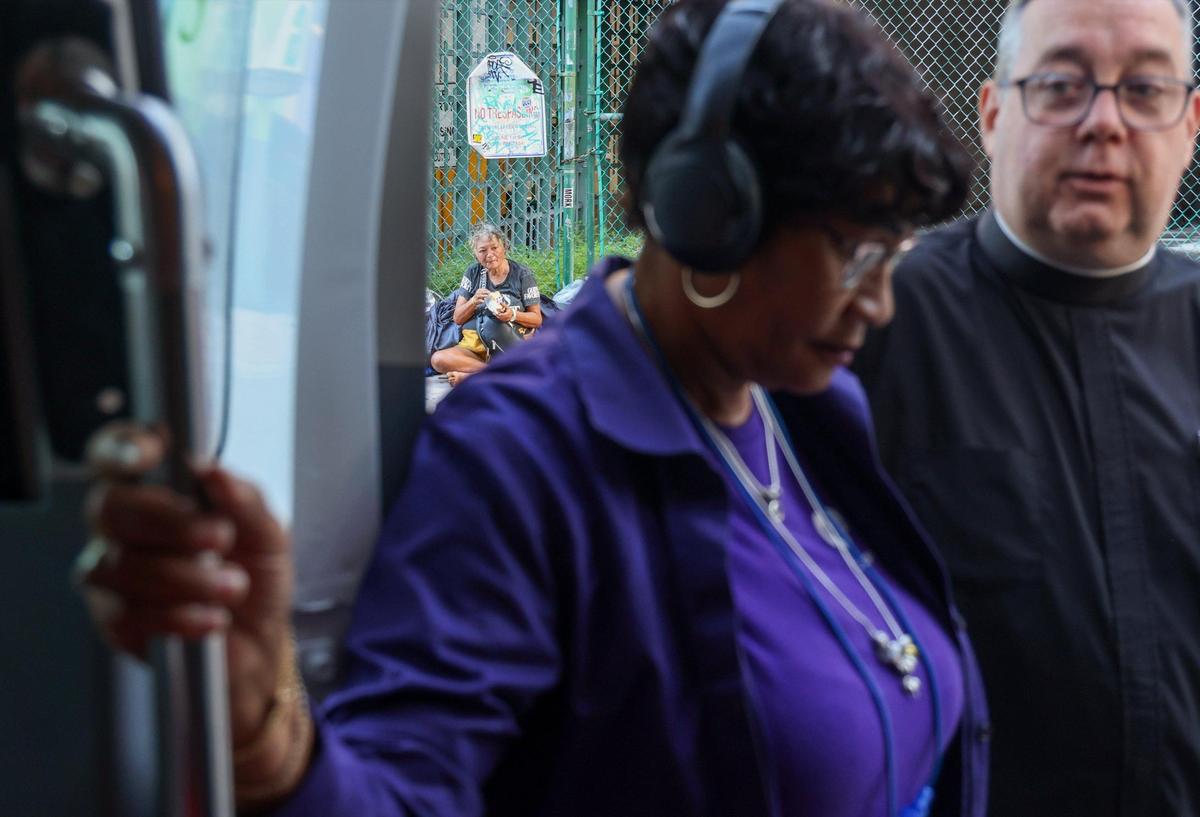 Clinician Mary Love, center, and Brother Sean McIsaac, right, provide health checkups to individuals experiencing homelessness on Monday, Nov. 11, 2024, in Miami. Their work is part of the Lazarus Project, a street outreach initiative run by Camillus House in conjunction with Miami-Dade County’s Homeless Trust.