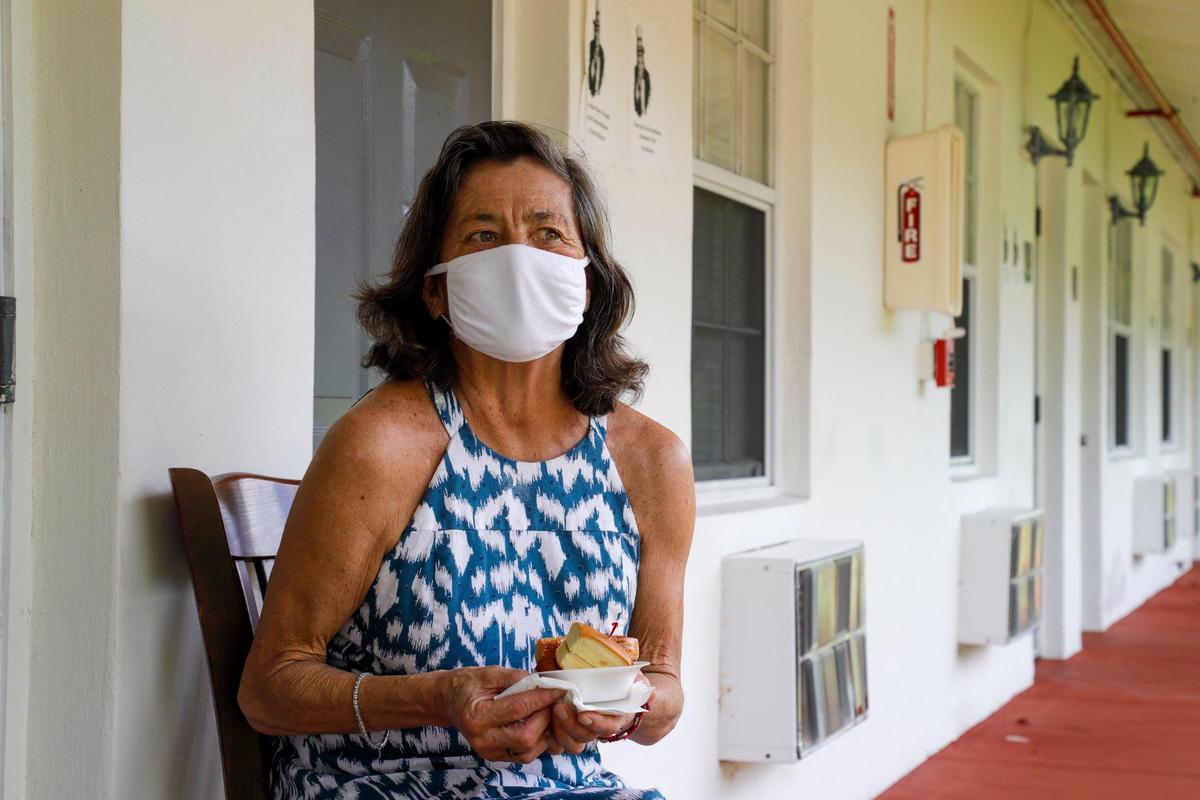 Virginia “Jeannie” Mayhall, 65, holds her afternoon snack in the hallway outside her bedroom door at Mia Casa, the former assisted living center in North Miami that the Miami-Dade County Homeless Trust is leasing to house senior citizens in Miami who are homeless.