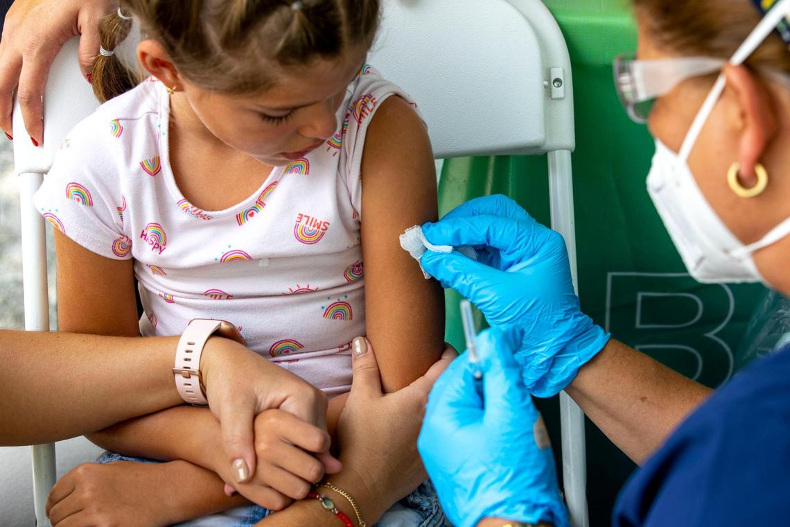 Mia Diaz, 7, prepares to get a COVID-19 vaccine at the Nomi Health Mobile Health Unit inside Tropical Park in Miami, Florida, on Saturday, June 25, 2022. On Saturday, Miami-Dade County began offering the vaccines to children under age 5, the last group to be authorized to receive the vaccines.