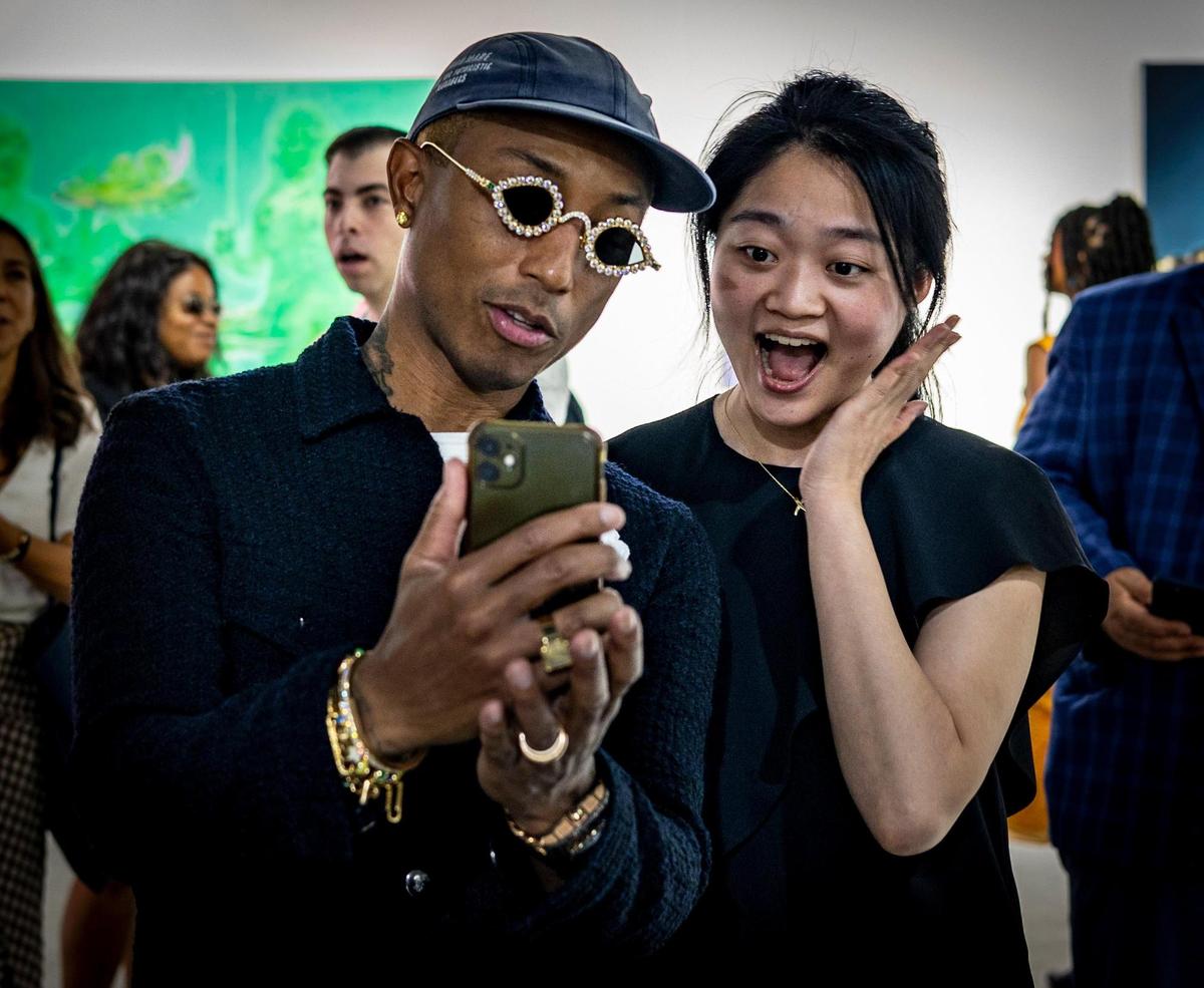 Pharrell Williams, left, takes a selfie with a fan at the Art Basel VIP opening day in Miami Beach.