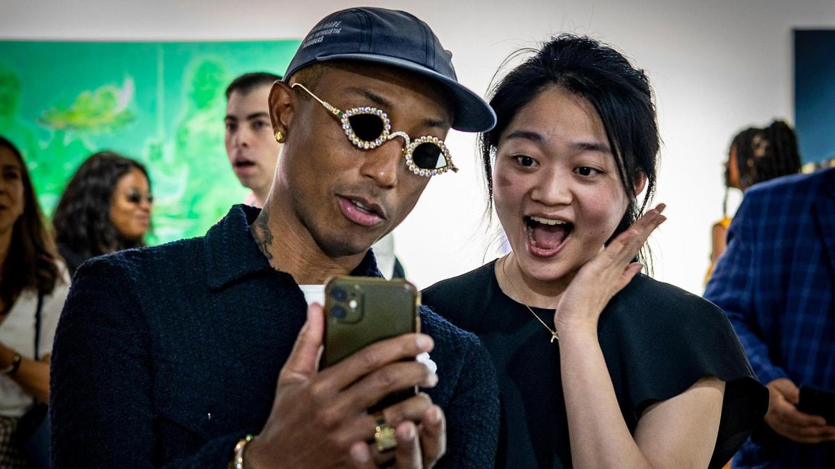 Pharrell Williams, left, takes a selfie with a fan at the Art Basel VIP opening day in Miami Beach.