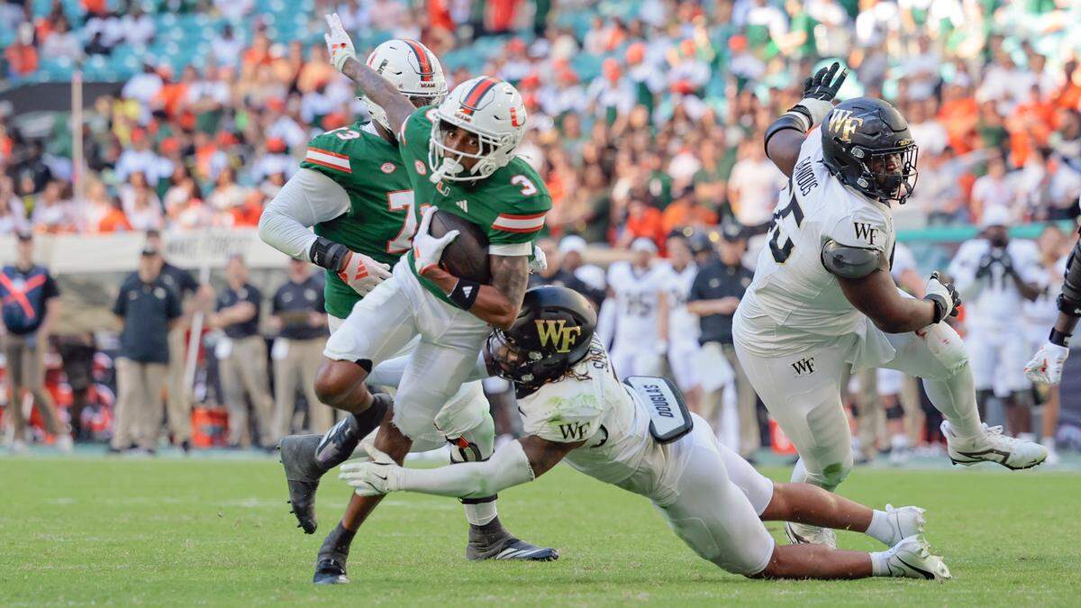 Miami Hurricanes wide receiver Jacolby George (3) breaks a tackle Wake Forest Demon Deacons defensive back Evan Slocum (7) on his way to score in the second half of their NCAA game in Miami Gardens, Florida, on Saturday, November 23, 2024.