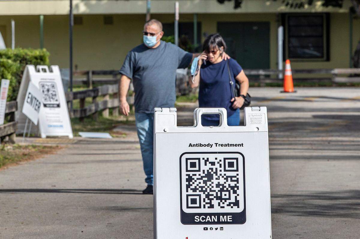A couple walk out after visiting a monoclonal antibodies distribution site to treat COVID-19, at Tropical Park on Tuesday afternoon, Jan. 4, 2021.