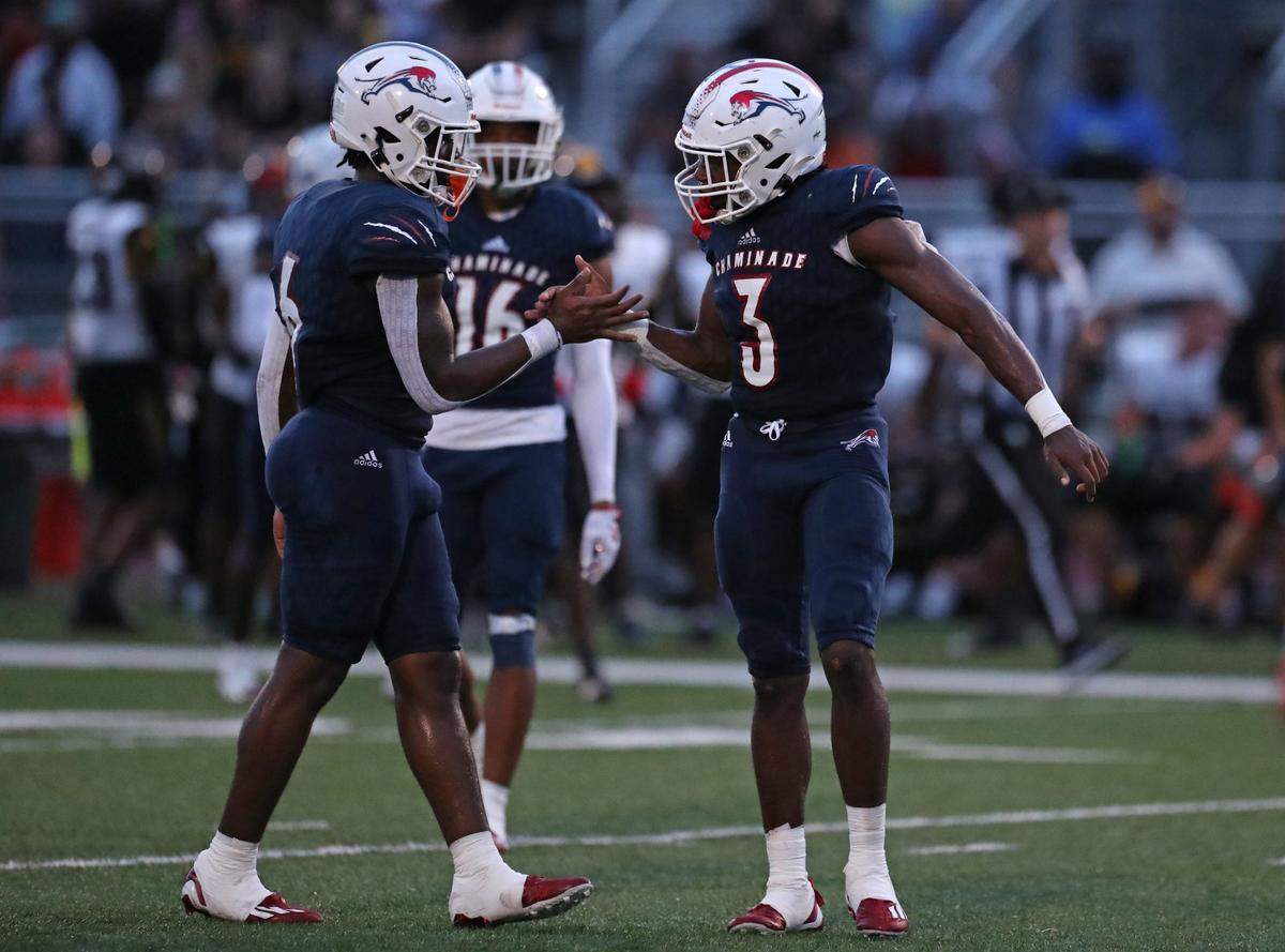 Chaminade-Madonna linebacker Denzel Johnson high fives safety Jeno Junius after a stop on third down against American Heritage during the first half on Friday, Sept. 16, 2022 in Hollywood.