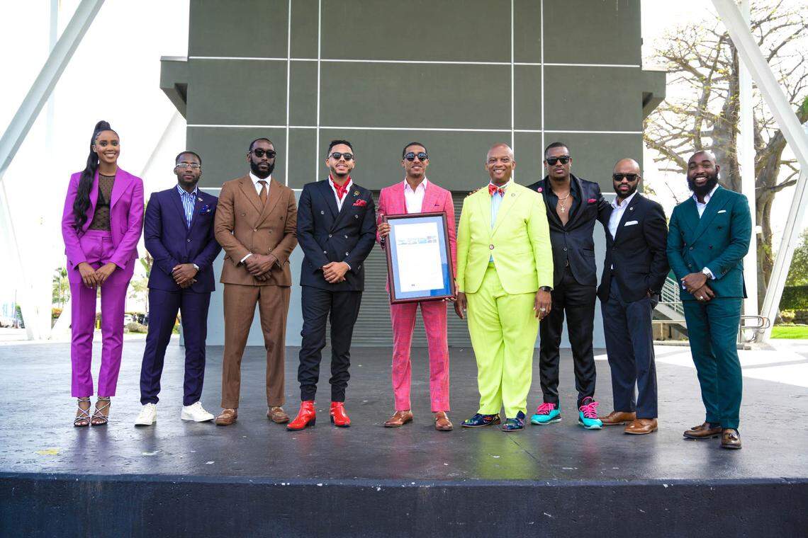 NeAndre Broussard, center, poses with Miami-Dade Commissioner Oliver Gilbert III, fourth from right, at the 2021 Black Menswear FlashMob in Miami on Dec. 18, 2021. Gilbert issued a proclamation declaring the day Black Menswear FlashMob Day.