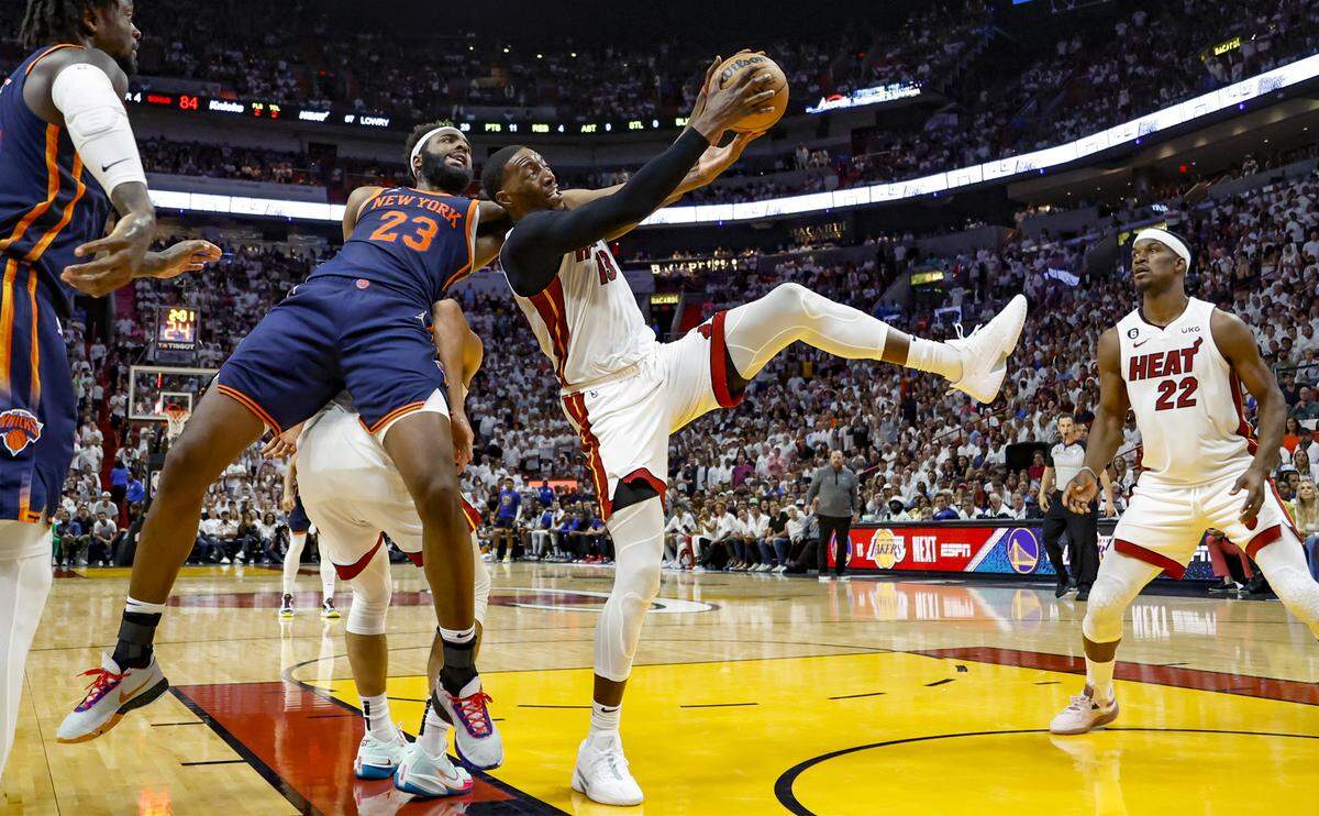 Miami Heat center Bam Adebayo (13) rebounds the ball away from New York Knicks center Mitchell Robinson (23) late in the fourth quarter in Game 6 of the NBA Eastern Conference Semifinals at the Kaseya Center in Miami on Friday, May 12, 2023. The Heat advanced to the Eastern Conference Finals after defeating the Knicks.