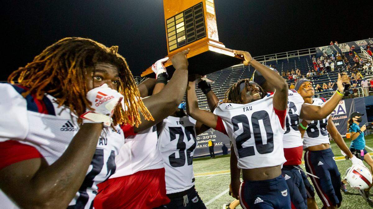 Florida Atlantic University players hoist the Don Shula Trophy after defeating Florida International University 38-19 in the ’2020 Shula Bowl’, at Riccardo Silva Stadium, in Miami, Florida, on Friday, November 13, 2020.