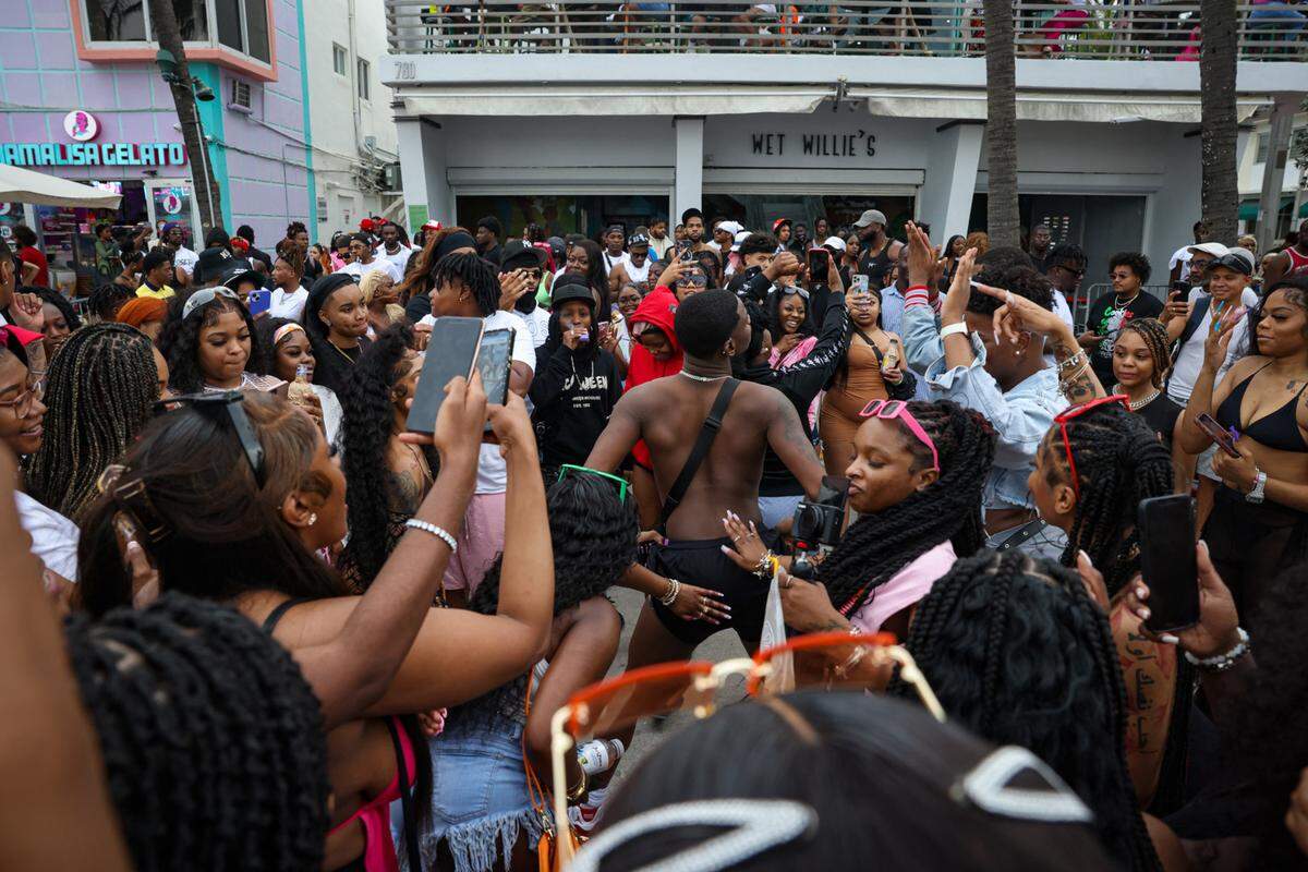 Keandre Reese, center, dances in a crowd of spring breakers front of Wet Willies on Sunday, March 19, 2023, on Ocean Drive in Miami Beach.
