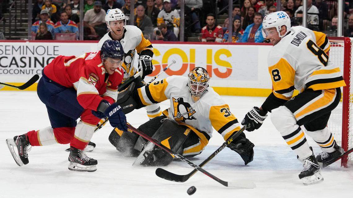 Pittsburgh Penguins goaltender Tristan Jarry (35) and defenseman Brian Dumoulin (8) defend the goal against Florida Panthers’ Grigori Denisenko (14) during the second period of an NHL hockey game, Thursday, Dec. 15, 2022, in Sunrise, Fla. (AP Photo/Lynne Sladky)
