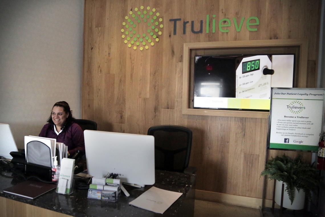 Ariana Delgado greets customers in the lobby at Trulieve, where customers wait to be seen by a patient consultant. Trulieve is located at 4020 NW 26th St. in Miami.