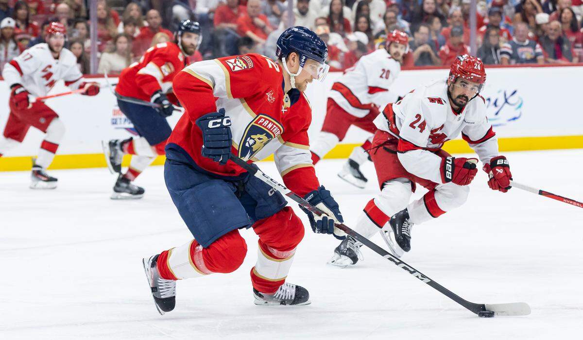 Florida Panthers defenseman Gustav Forsling (42) skates with the puck as Carolina Hurricanes center Seth Jarvis (24) defends in the first period of Game 4 during the Eastern Conference final of the NHL Stanley Cup playoffs at Amerant Bank Arena on Monday, May 26, 2025, in Sunrise, Fla.
