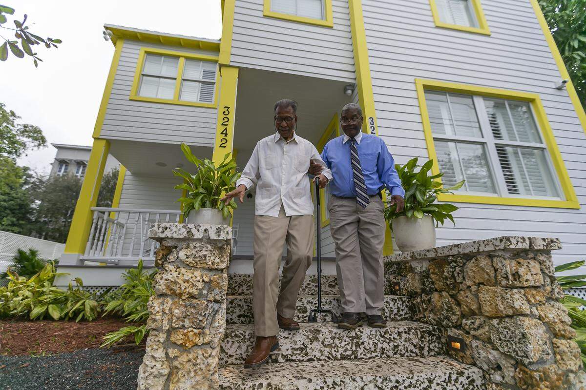 George Simpson, right, and his father, Dr. George Simpson, whose family owns the long-vacant 1897 E.W.F. Stirrup House in historically Black West Coconut Grove, have restored the home with the help of development partners. The historic home is now open as a bed-and- breakfast lodging. On Thursday, the Miami City Commission rezoned the lots across the street so they can build a companion Bahamian-style inn.
