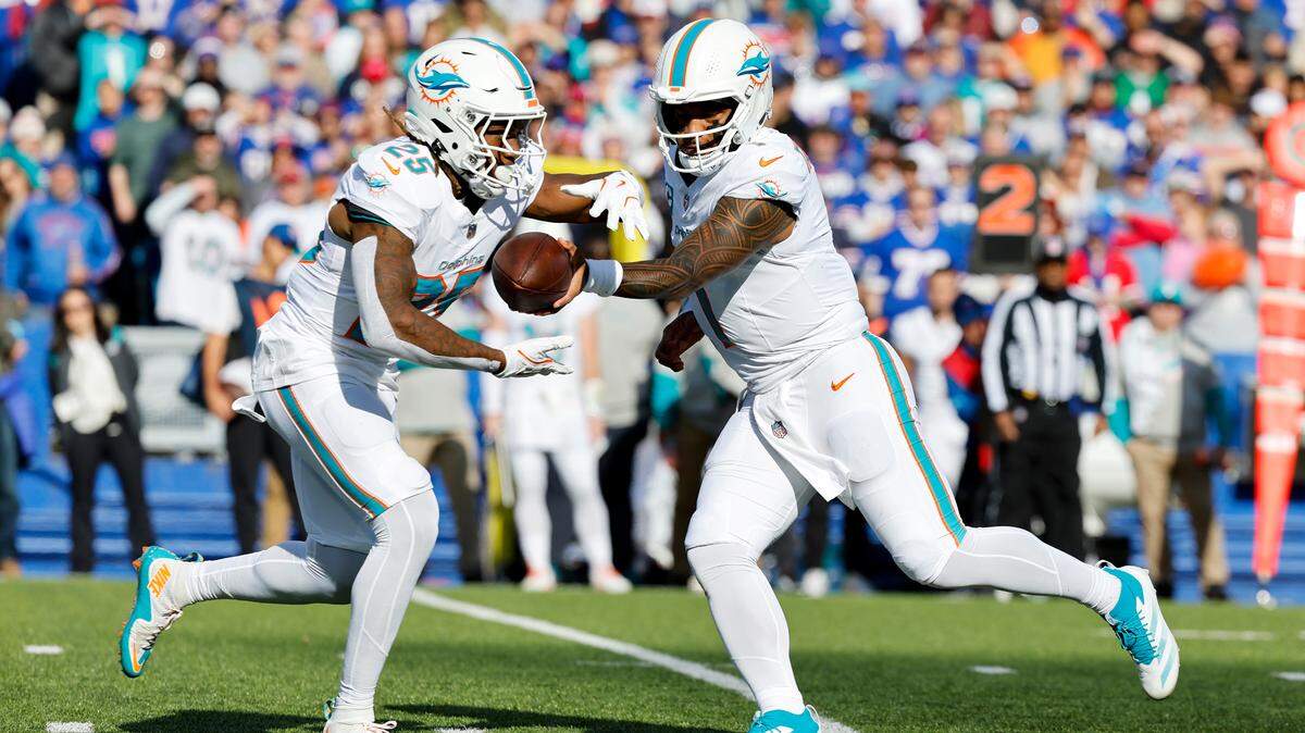 El quarterback de los Dolphins de Miami Tua Tagovailoa (der.) le da el ovoide al running back Jaylen Wright en el partido contra Buffalo Bills, celebrado el 3 de noviembre de 2024 en el Highmark Stadium en Orchard Park, Nueva York.