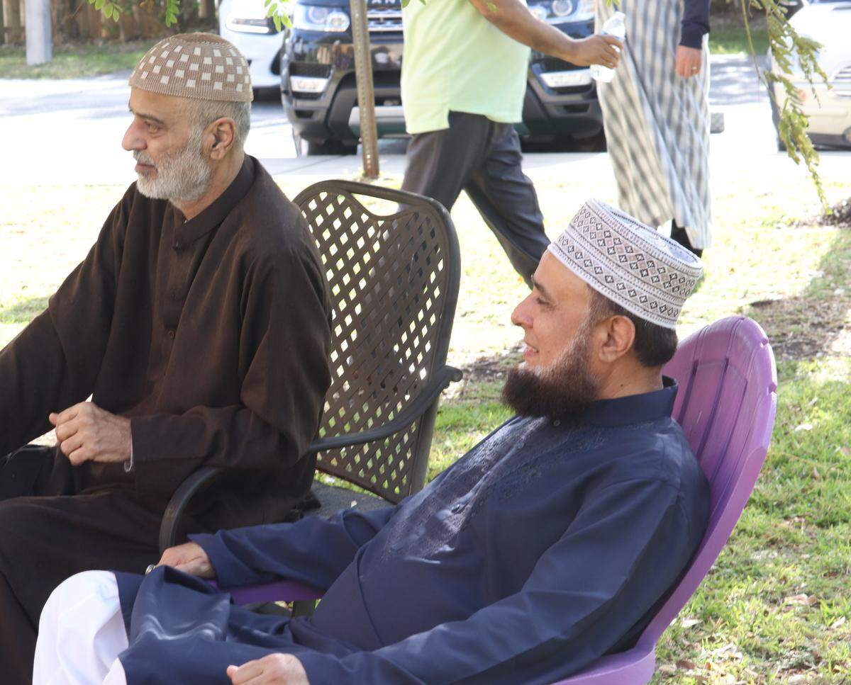 Two men sit in front of the Masjid An-Noor mosque in West Kendall, whose members celebrated Eid-ul-Fitr, Monday, May 2, 2022, marking the end of Ramadan, the holiest month in the Islamic calendar. It was the first time in two years that services were held in person as a result of the pandemic.