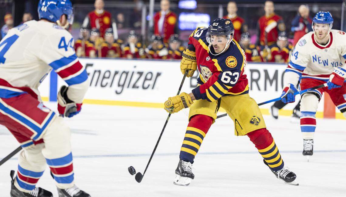 Florida Panthers left wing Brad Marchand (63) passes the puck as New York Rangers defenseman Vladislav Gavrikov (44) defends in the first period of their Winter Classic outdoor hockey game at loanDepot park on Friday, Jan. 2, 2026, in Miami, Fla.