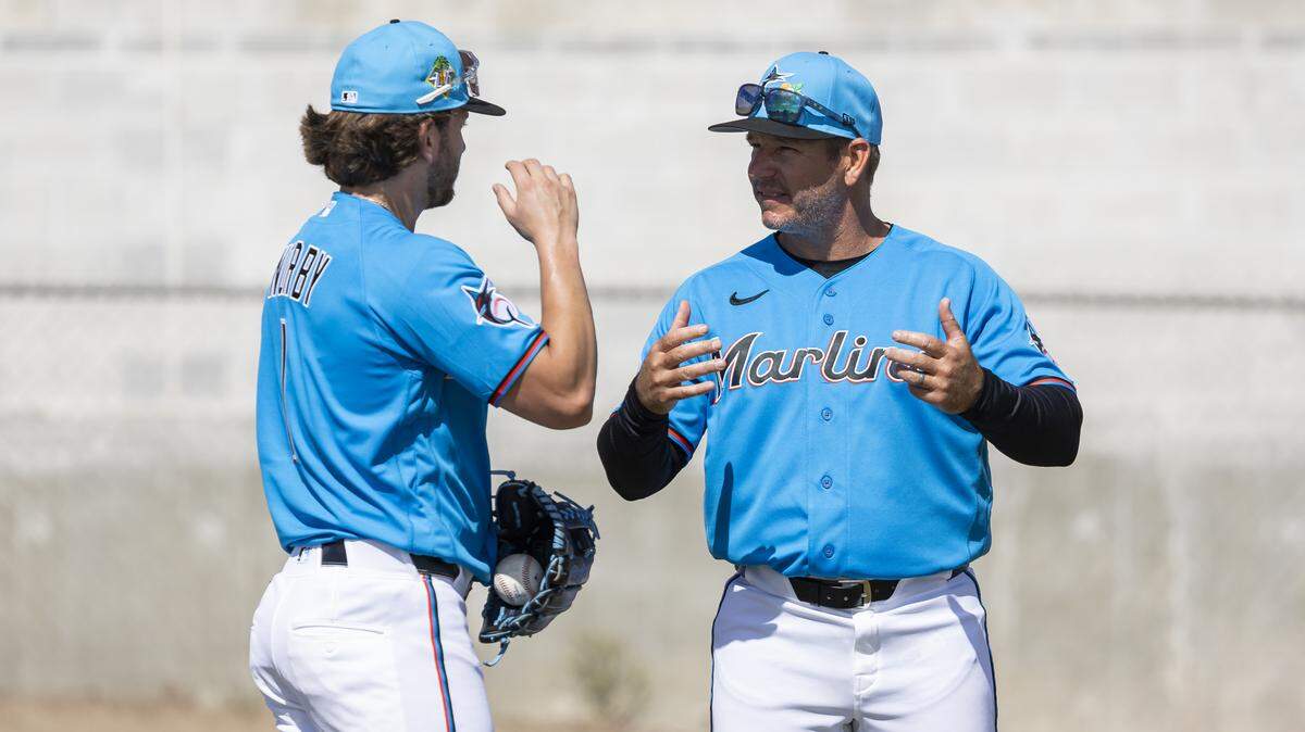 Miami Marlins third baseman Connor Norby (1) and manager Clayton McCullough (86) talk during the team’s first full-squad spring training workout at Roger Dean Stadium on Monday, Feb. 16, 2026, in Jupiter, Fla.