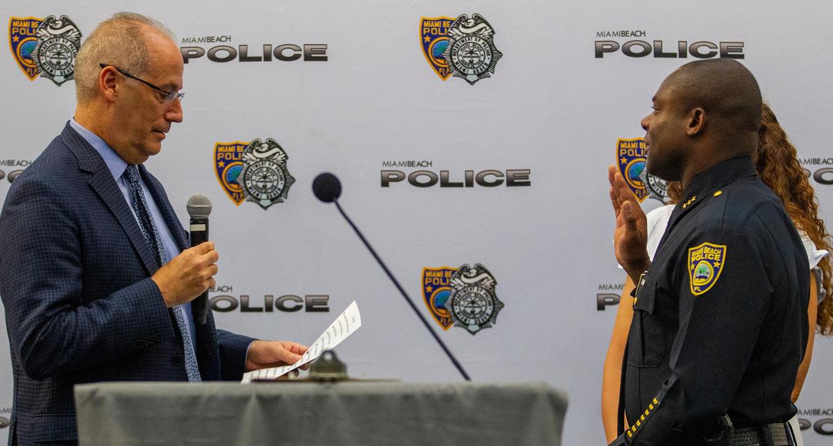 Miami Beach mayor Dan Gelber, left, recites the oath of office to new Miami Beach Police Deputy Chief Wayne Jones at Miami Beach City Hall in Miami Beach, Florida, on Monday, July 1, 2019.