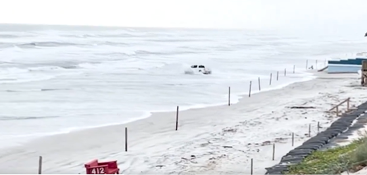 The driver weaves in and out of the surf, at one point facing the ocean while the truck was pushed ashore by the waves, the video shows.
