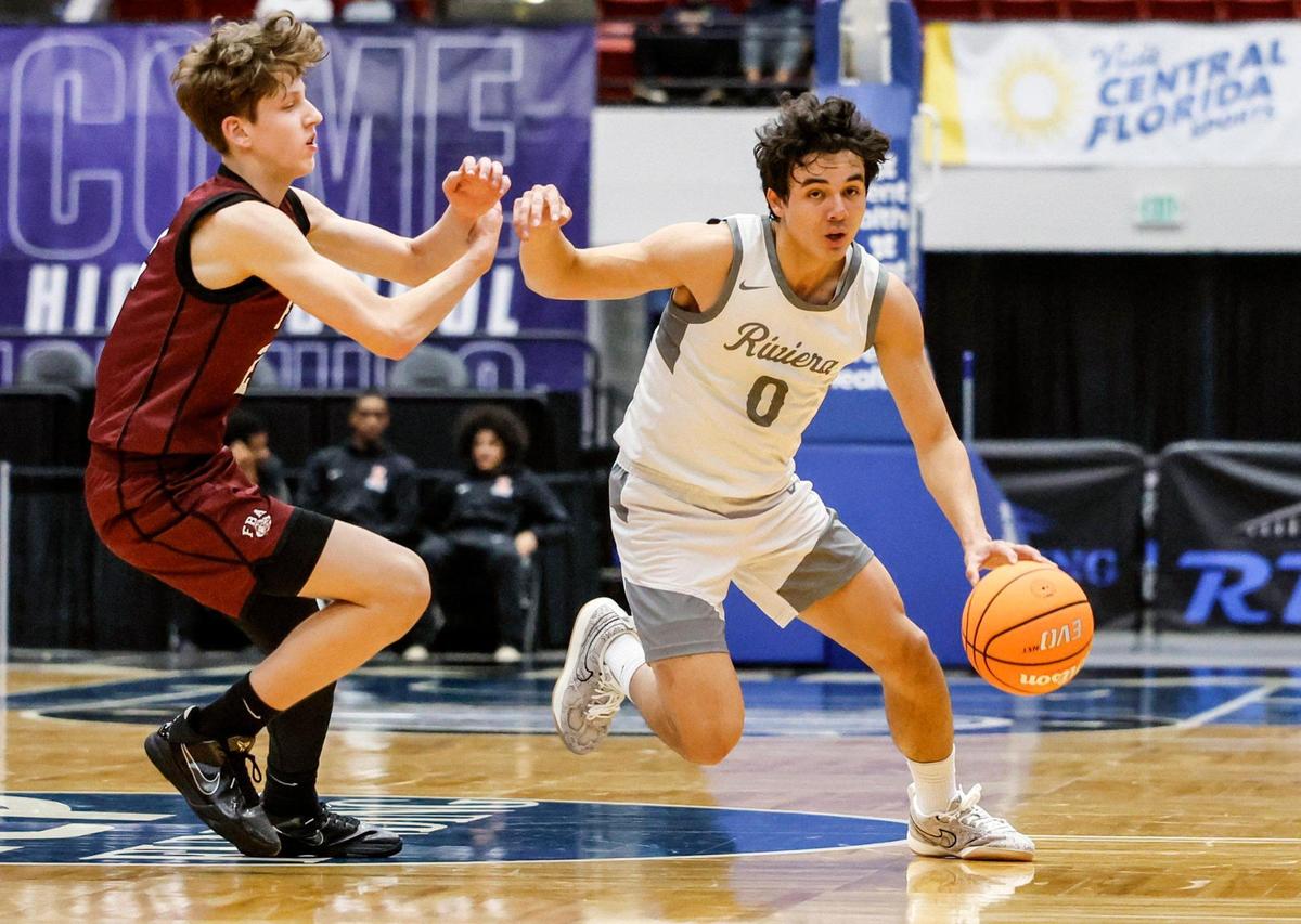 Riviera Prep’s Myles Fuentes (0) drives the ball as First Baptist’s Andrew Loveall (2) defends in the first half during Class 3A boy’s basketball state semifinal of the Florida High School State Championships at the RP Funding Center in Lakeland, Florida on Thursday, February 27, 2025.