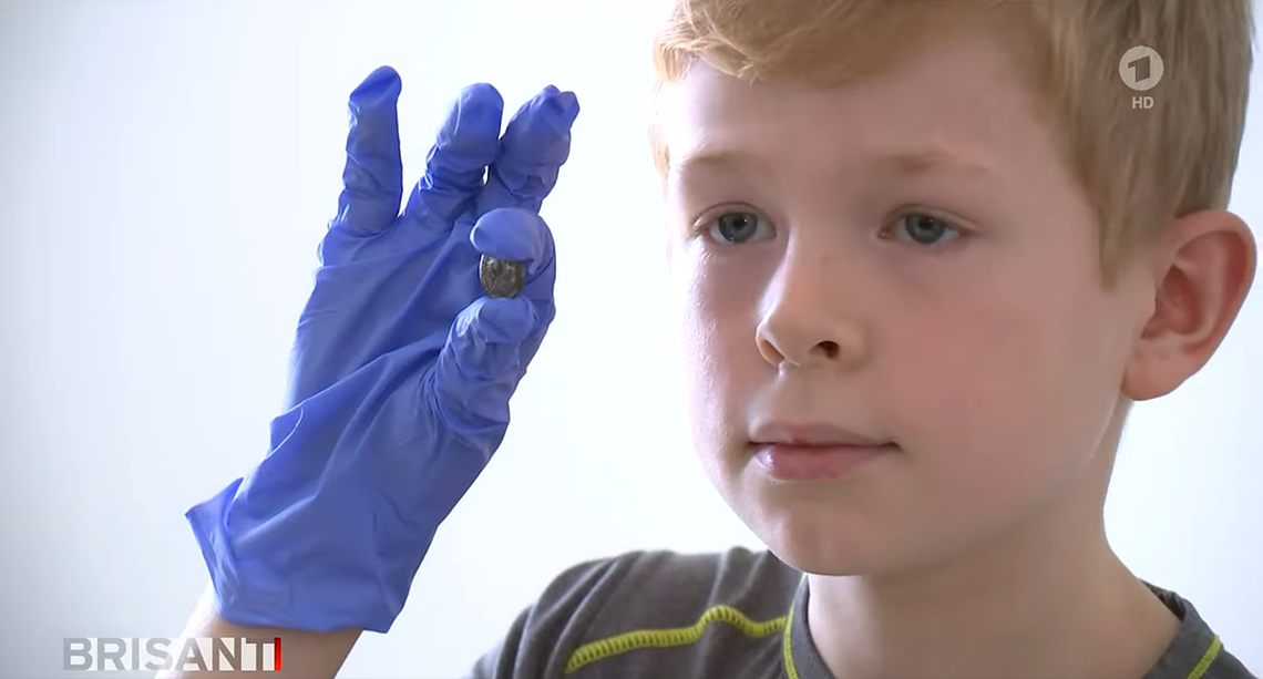 Bjarne holds the ancient Roman coin during a news conference.