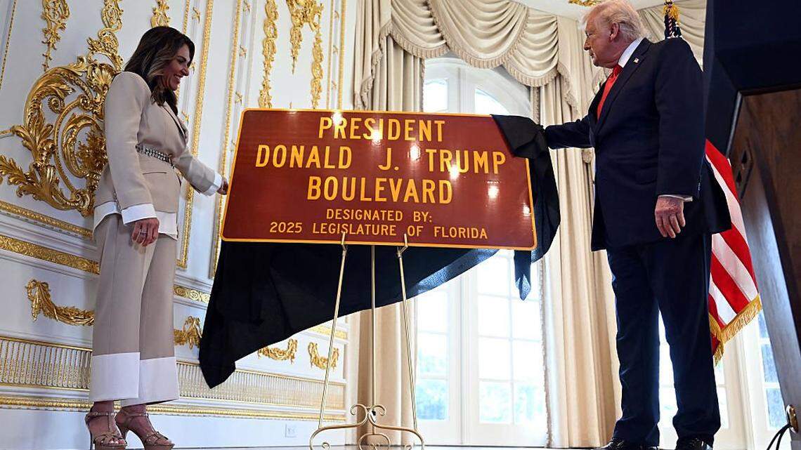 US President Donald Trump and Meg Weinberger (L), a Republican member of the Florida House of Representatives, unveil a road sign during a dedication ceremony for Southern Boulevard, in the ballroom at Mar-a-Lago in Palm Beach, Florida, on January 16, 2026. Palm Beach Southern Boulevard, between Kirk Road and South Ocean Boulevard, is being renamed as "President Donald J. Trump Boulevard." (Photo by ANDREW CABALLERO-REYNOLDS / AFP via Getty Images)