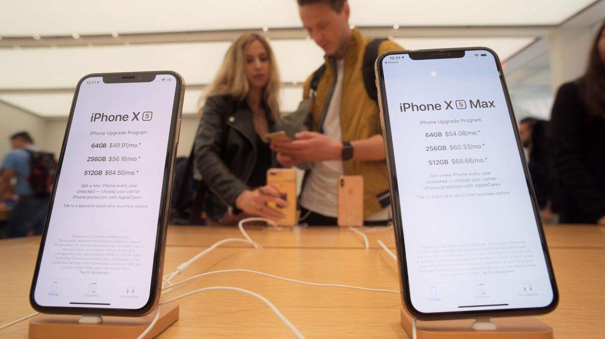 Customers look at new Apple iPhones, including the iPhone XS, left, and iPhone XS Max on display at an Apple store in New York on Friday, Sept. 21, 2018.