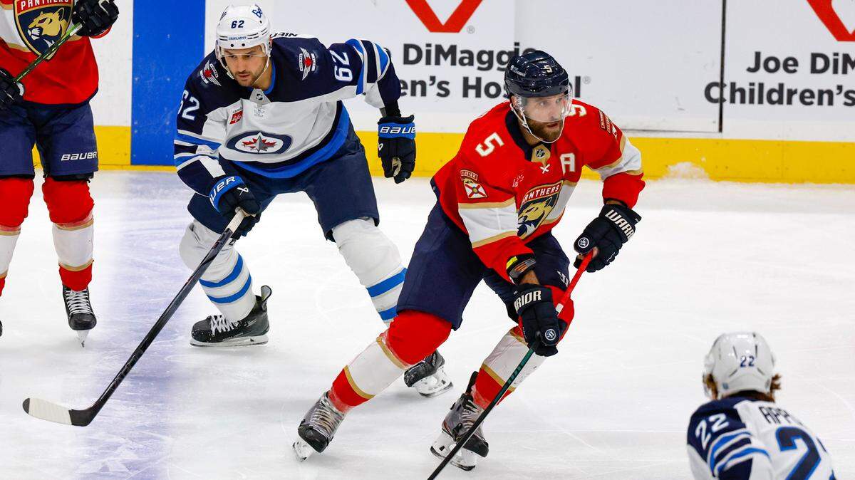 Florida Panthers defenseman Aaron Ekblad (5) controls the puck around Winnipeg Jets right wing Nino Niederreiter (62) and center Mason Appleton (22) in the first period at Amerant Bank Arena in Sunrise on Friday, November 24, 2023.