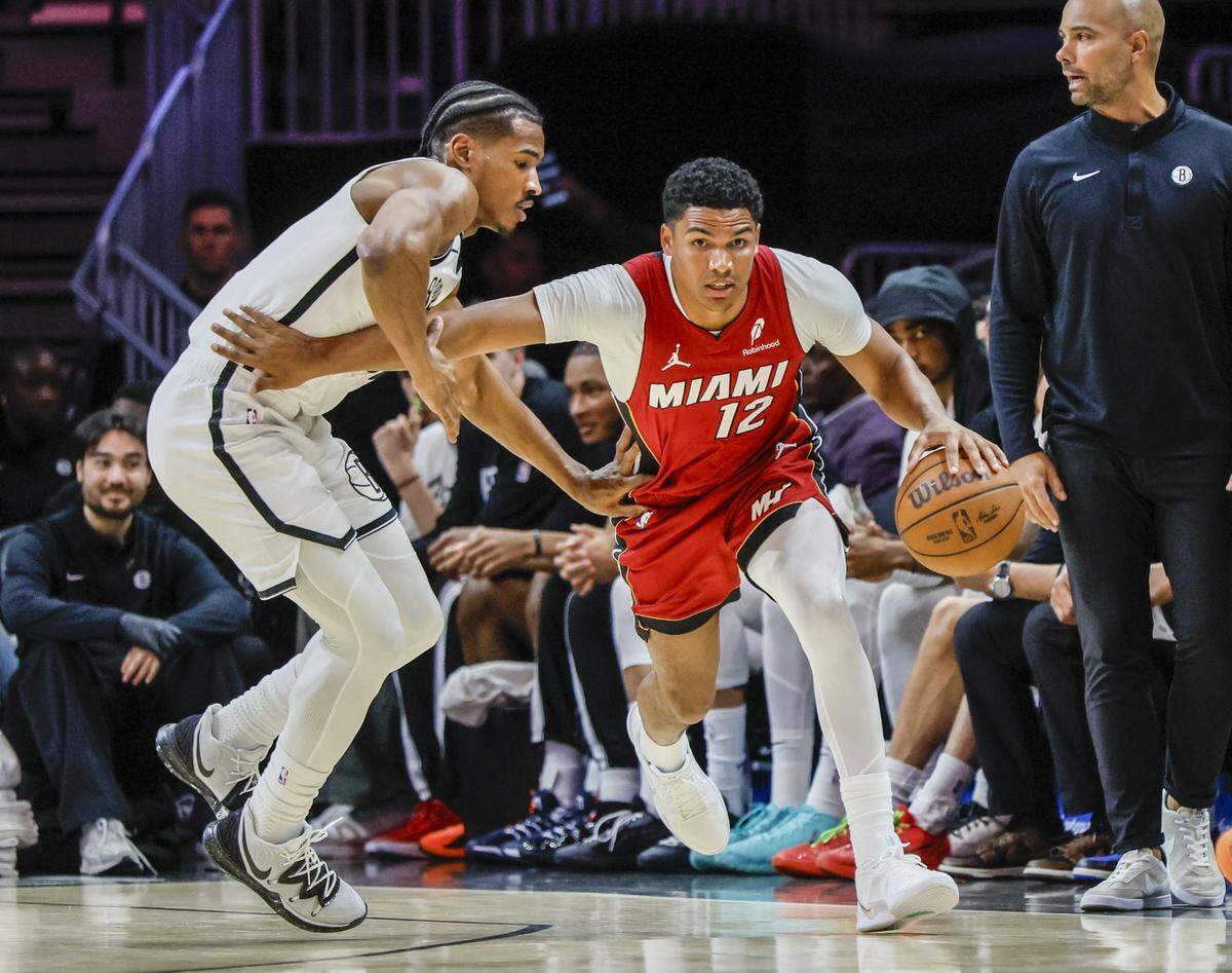 Miami Heat guard Dru Smith (12) grabs a rebound as Brooklyn Nets guard Ochai Agbaji (30) defends during their NBA basketball game at Kaseya Center in Miami on March 5, 2026.